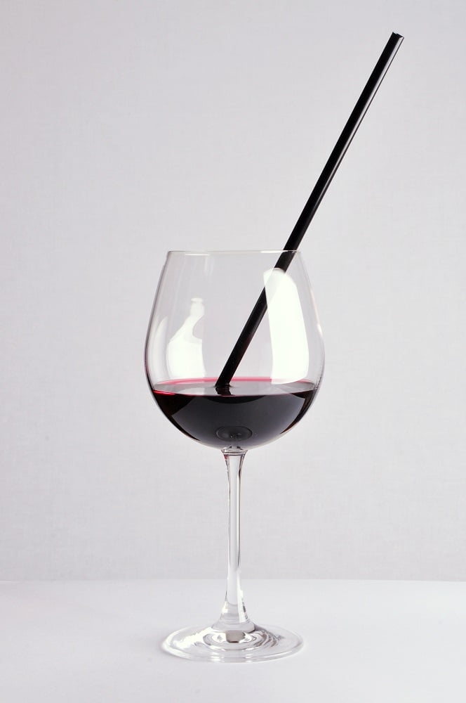 Weinglas mit Strohhalm – humorvolles Stillleben in symmetrischer Komposition